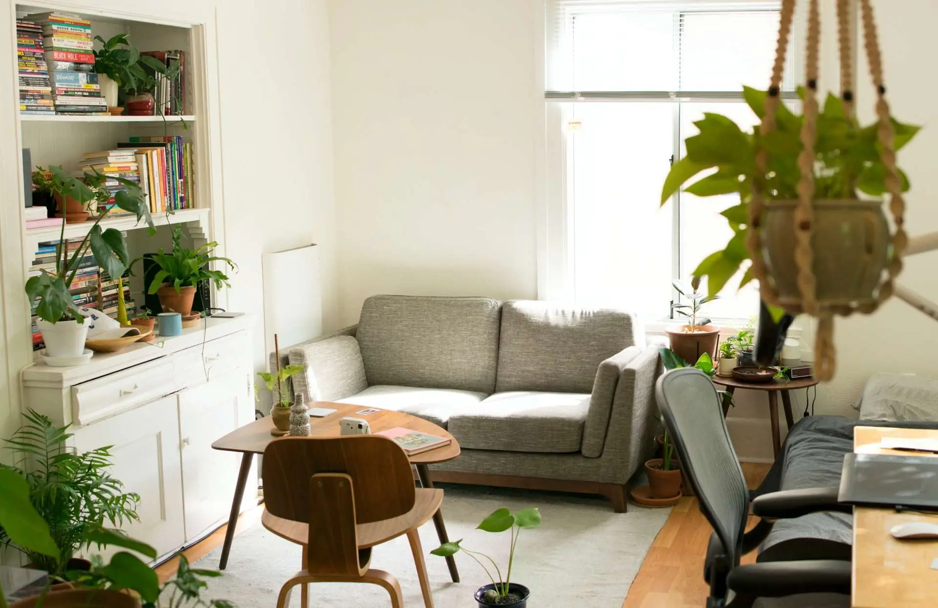 Fully furnished room with table, bookcase, sofa and desk