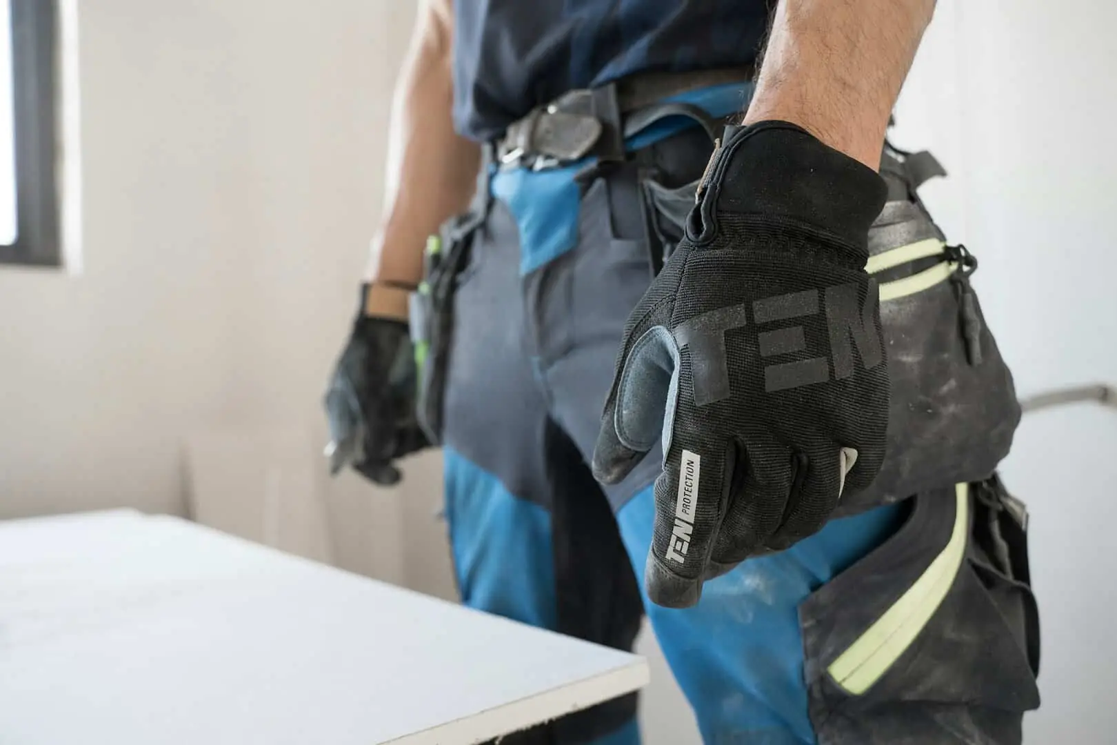 Close-up of a mover wearing a black protective glove and a tool belt, ready for safe manual handling