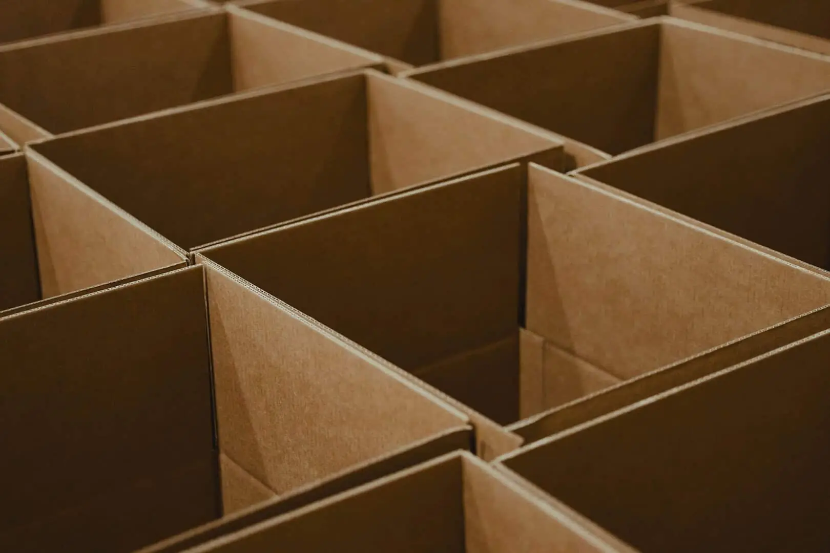 A grid of empty, sturdy cardboard removal boxes, ready for packing fragile glassware and kitchen items safely for a move.