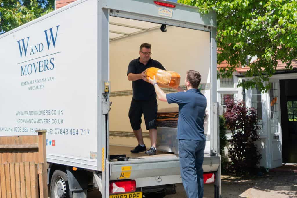 Two people unload stuff from removal van