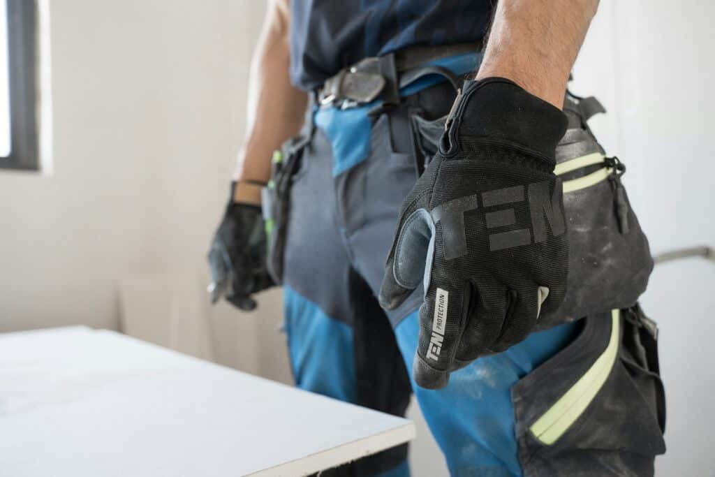 Close-up of a mover wearing a black protective glove and a tool belt, ready for safe manual handling